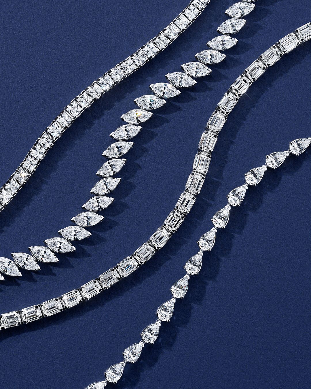 Diamond tennis bracelets with different stone cuts on navy blue velvet