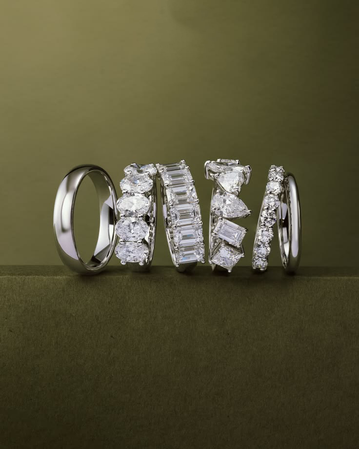 Diamond bands with round, emerald and mixed-cut stones on an olive background
